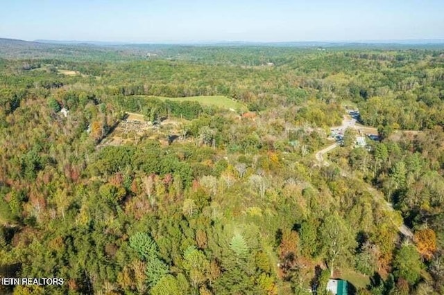 drone / aerial view featuring a wooded view