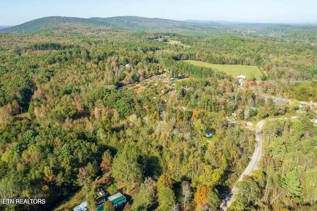 drone / aerial view with a mountain view and a view of trees