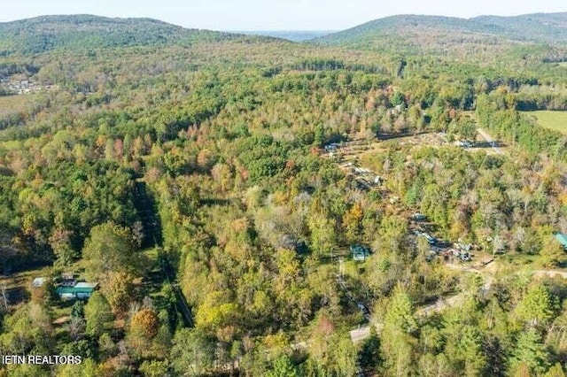 birds eye view of property with a mountain view and a wooded view