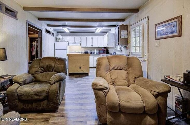 living room with dark wood-type flooring and beamed ceiling