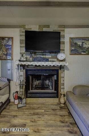 interior details with a fire extinguisher, a fireplace, and wood finished floors