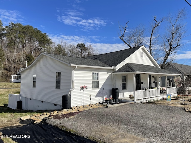 view of front of property featuring a porch, driveway, roof with shingles, and crawl space