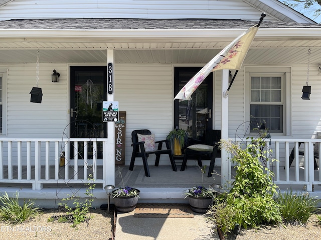 view of exterior entry featuring covered porch