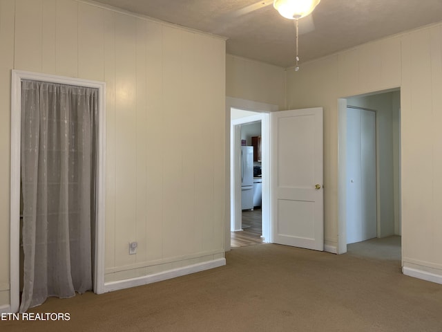 carpeted spare room with ceiling fan