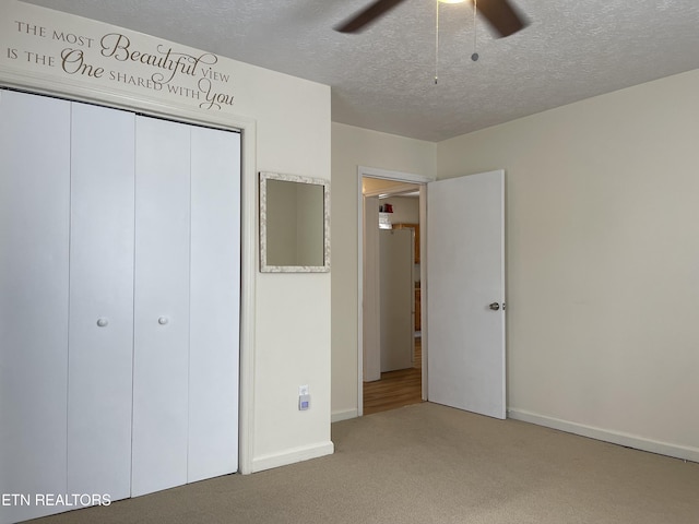 unfurnished bedroom featuring a closet, carpet flooring, baseboards, a ceiling fan, and a textured ceiling