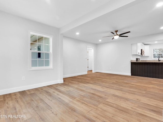 unfurnished living room featuring light wood-style flooring, baseboards, ceiling fan, and recessed lighting