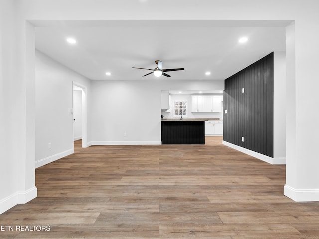 unfurnished living room with light wood-type flooring, ceiling fan, baseboards, and recessed lighting