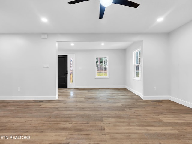 spare room featuring baseboards, wood finished floors, and recessed lighting