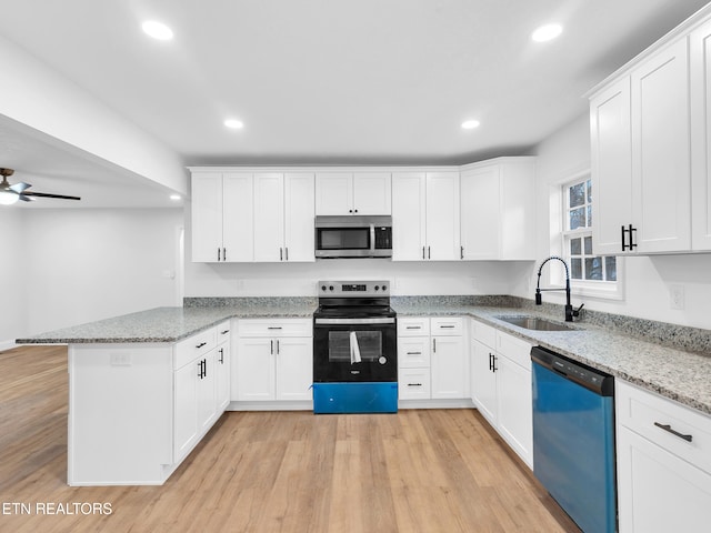 kitchen with stainless steel microwave, electric range oven, a sink, dishwasher, and a peninsula