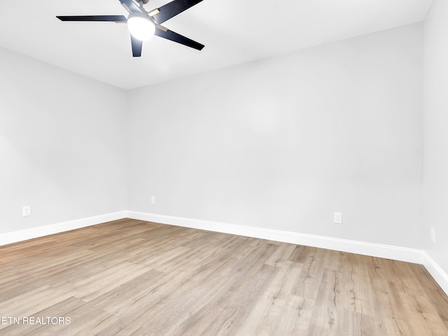 empty room with ceiling fan, wood finished floors, and baseboards