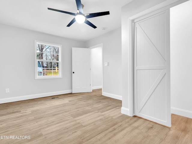 unfurnished room with light wood finished floors, ceiling fan, visible vents, and baseboards