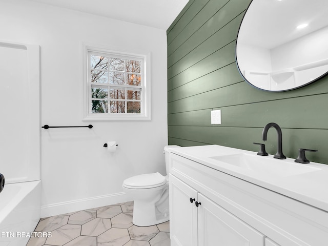 full bath featuring baseboards, toilet, marble finish floor, a washtub, and vanity