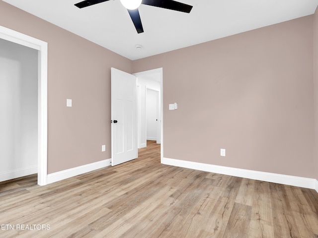 unfurnished bedroom with ceiling fan, light wood-type flooring, and baseboards