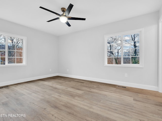 spare room featuring plenty of natural light, visible vents, and wood finished floors