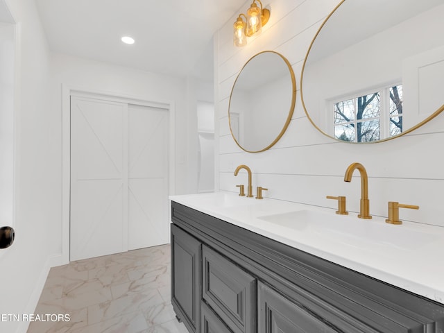 bathroom featuring double vanity, marble finish floor, a sink, and recessed lighting