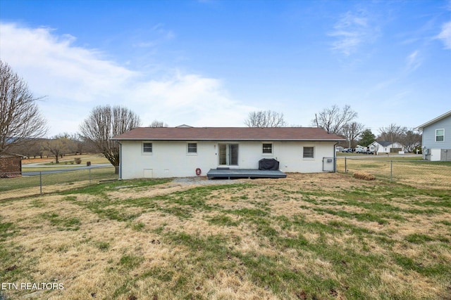 rear view of house featuring a fenced backyard, a lawn, and a wooden deck