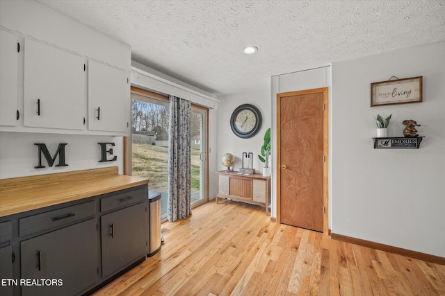 interior space with a textured ceiling, light wood finished floors, and plenty of natural light