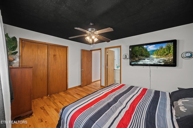 bedroom with a ceiling fan, light wood-type flooring, a closet, and a textured ceiling