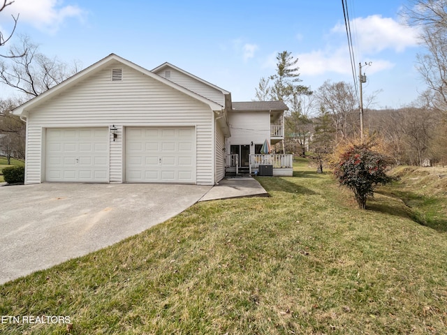 view of front of property with a garage, driveway, cooling unit, and a front yard