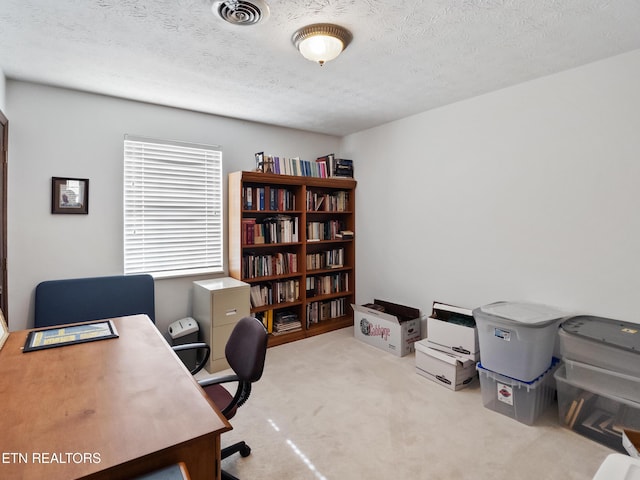 office space with a textured ceiling, carpet flooring, and visible vents