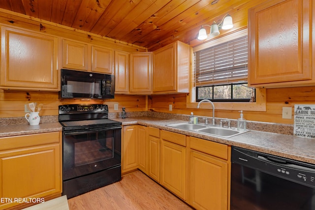 kitchen featuring black appliances, a sink, light wood finished floors, wood ceiling, and light countertops