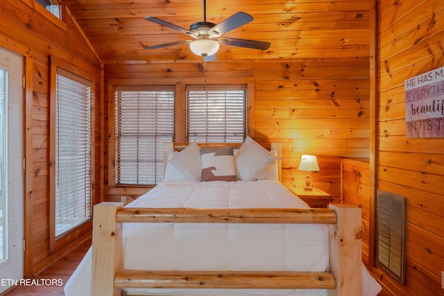 bedroom featuring visible vents, wood walls, wooden ceiling, and vaulted ceiling