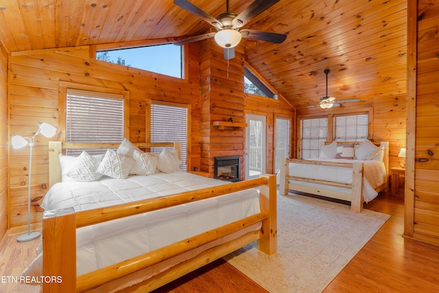 bedroom featuring light wood-style floors, wood ceiling, and wood walls