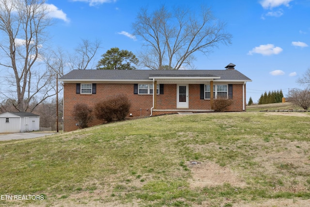 ranch-style home with a front yard and brick siding