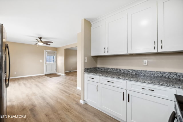 kitchen with light stone counters, light wood finished floors, a ceiling fan, white cabinetry, and stainless steel fridge with ice dispenser