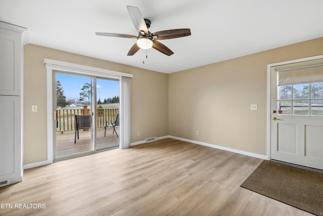 interior space with baseboards, ceiling fan, visible vents, and light wood-style floors