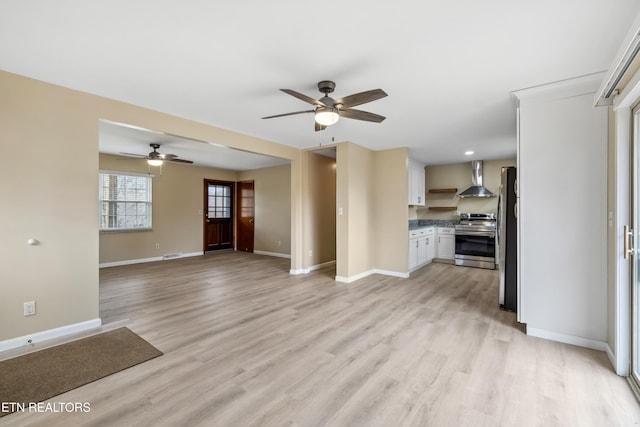 unfurnished living room with ceiling fan, light wood-style flooring, and baseboards