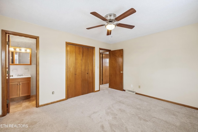 unfurnished bedroom with a closet, light colored carpet, visible vents, and baseboards