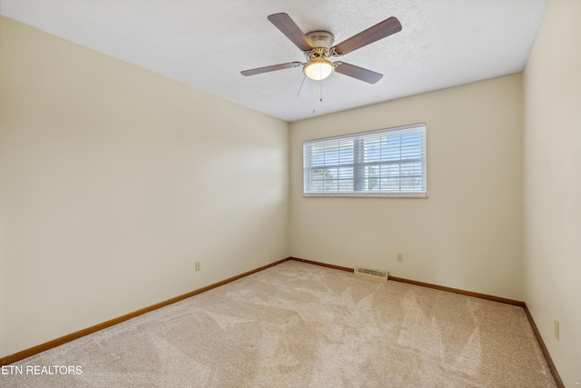 empty room with baseboards, visible vents, a ceiling fan, a textured ceiling, and carpet floors