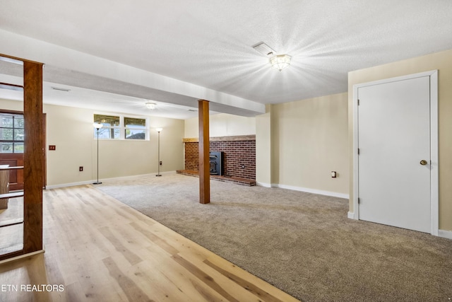 below grade area with carpet flooring, a textured ceiling, and baseboards