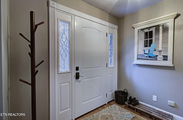 entrance foyer featuring wood finished floors and a textured ceiling