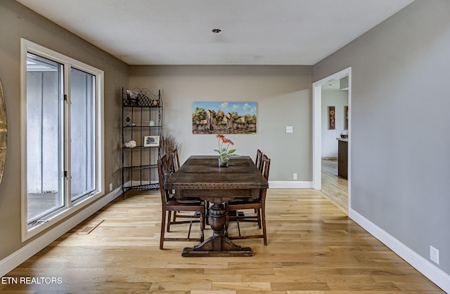 dining area with baseboards and light wood-type flooring