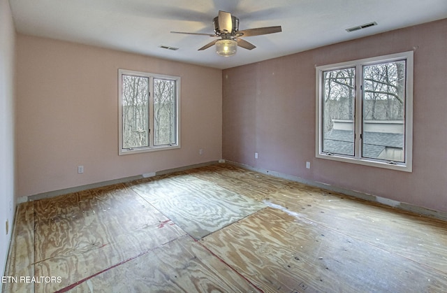 empty room with visible vents, plenty of natural light, and baseboards