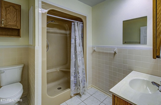 full bath featuring tile patterned flooring, a shower stall, toilet, vanity, and tile walls