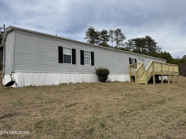 exterior space featuring a front yard and a wooden deck