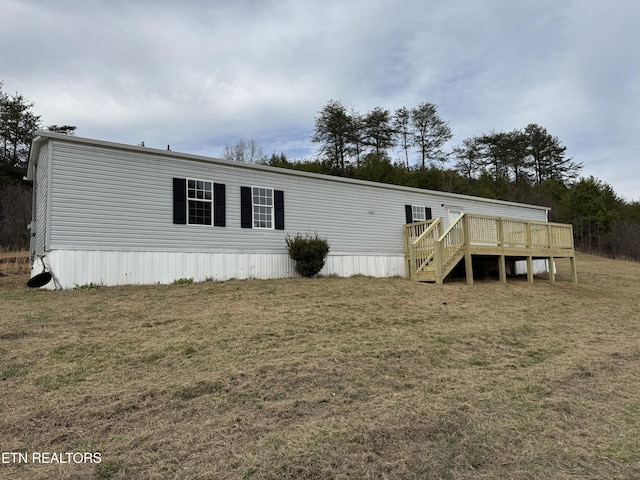 view of front of property with a deck, a front lawn, and stairs