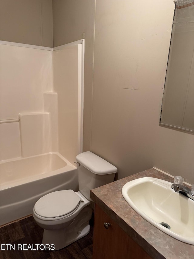 bathroom featuring toilet, shower / bath combination, wood finished floors, and vanity