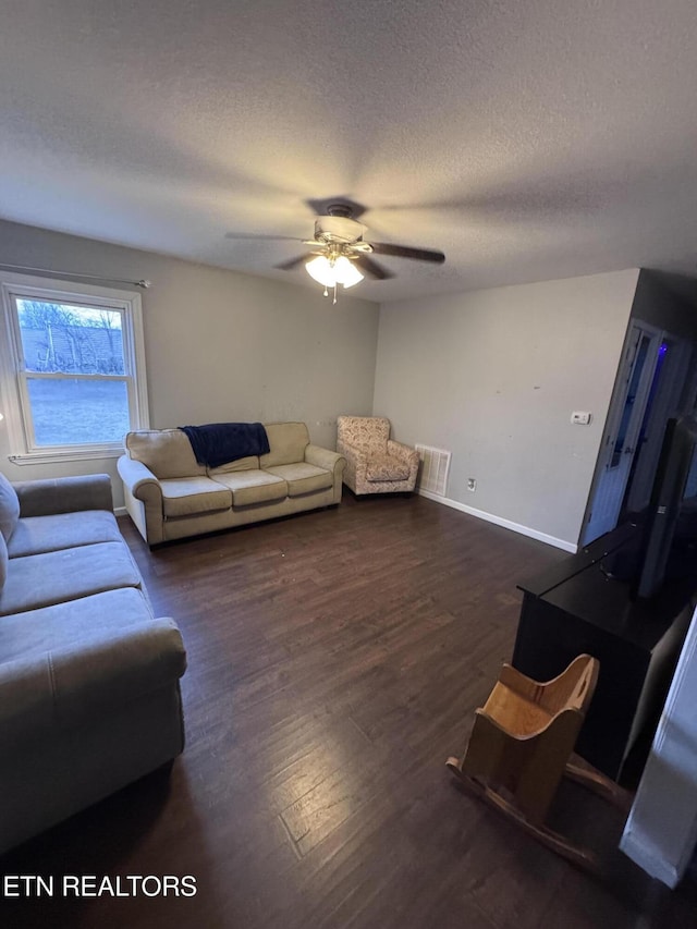 living room with visible vents, ceiling fan, baseboards, wood finished floors, and a textured ceiling