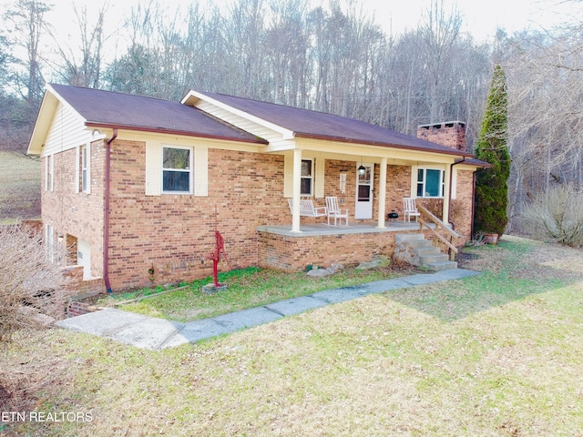 ranch-style home with covered porch, a front lawn, and brick siding