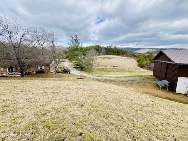 view of yard with an outbuilding, a pole building, and a mountain view