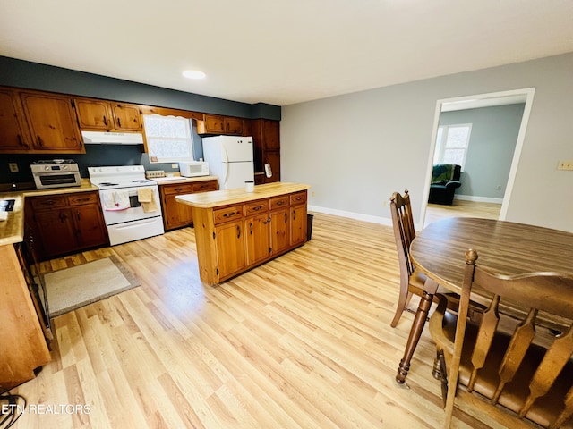 kitchen with white appliances, under cabinet range hood, baseboards, and light wood-style floors