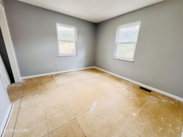 unfurnished room with baseboards and visible vents