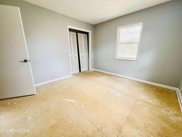 unfurnished bedroom with a closet and baseboards