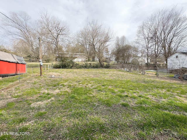 view of yard with an outdoor structure and fence