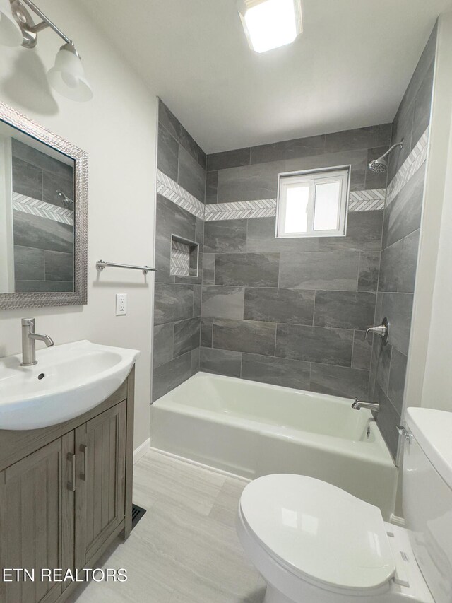 full bath featuring bathing tub / shower combination, vanity, and toilet