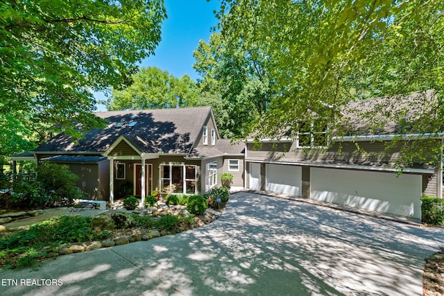 view of front of home featuring a garage, concrete driveway, and a porch